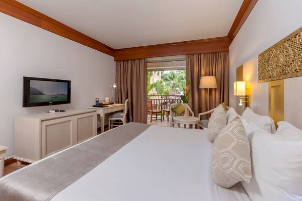 Zimmer im Best Western Premier Bangtao Beach Resort mit Fernseher, Schreibtisch und Balkonzugang.