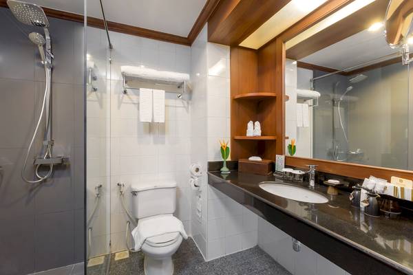 Badezimmer im Best Western Premier Bangtao Beach Resort mit Dusche, Toilette, Waschbecken und Spiegel.