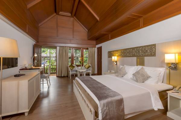 Schlafzimmer im Best Western Premier Bangtao Beach Resort mit Doppelbett, Nachttischen und Wandlampen.