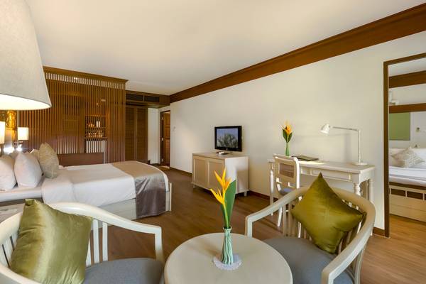 Innenansicht des Best Western Premier Bangtao Beach Resort Zimmers mit Bett, Schreibtisch und Möbeln.