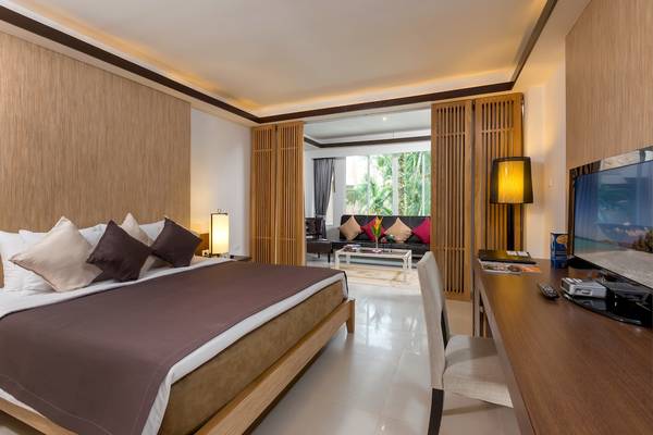 Hotelzimmer des Best Western Premier Bangtao Beach Resort mit Bett, Fernseher und Sofa.