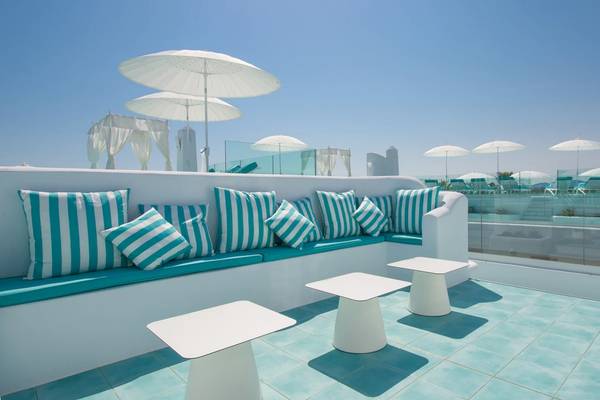 Außenbereich des Iberostar Selection Albufera Playa Hotels mit Pool, Loungemöbeln und Sonnenschirmen.