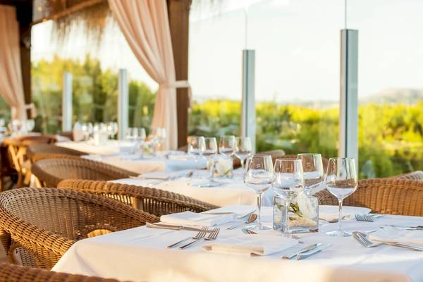 Innenansicht des Restaurants im Iberostar Selection Albufera Playa Hotel mit gedeckten Tischen und Blick auf eine ländliche Landschaft.