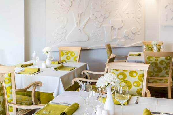 Innenansicht des Restaurants im Iberostar Selection Albufera Playa Hotel mit weißen Tischen und gelben Stühlen.