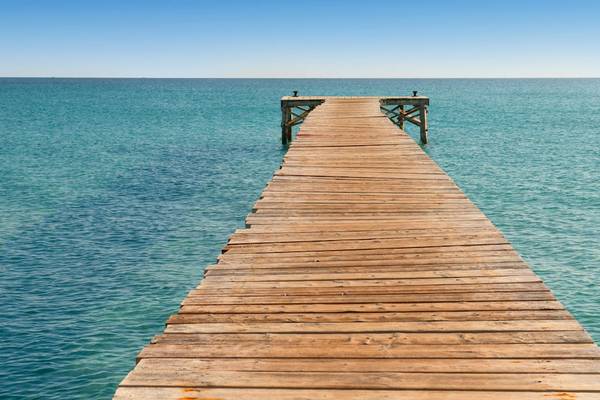 Holzpier im Ozean mit dem Iberostar Selection Albufera Playa Hotel im Hintergrund