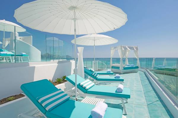 Hotel Iberostar Selection Albufera Playa mit Lounge-Bereich und Sonnenschirmen am Meer