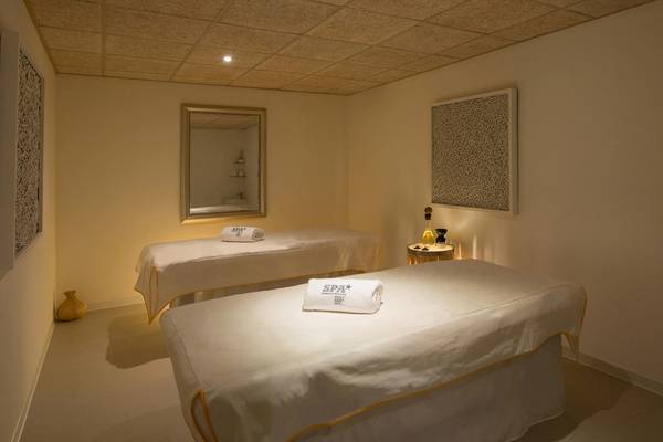 Spa-Behandlungsraum im Iberostar Selection Albufera Playa Hotel mit zwei Massagetischen, weißen Handtüchern und Ambientbeleuchtung.