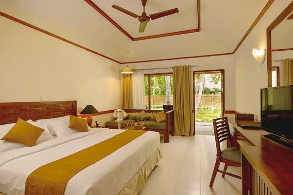 Innenansicht eines Hotelzimmers im Villa Park, Malediven, mit Bett, Schreibtisch und Fernseher.
