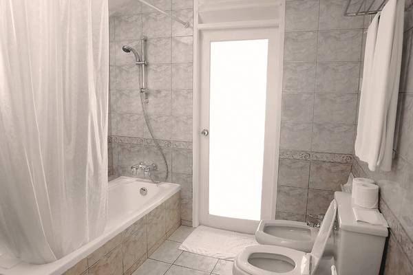 Badezimmer der Villa Park, Malediven, mit Badewanne, Dusche, Toiletten und Handtüchern.