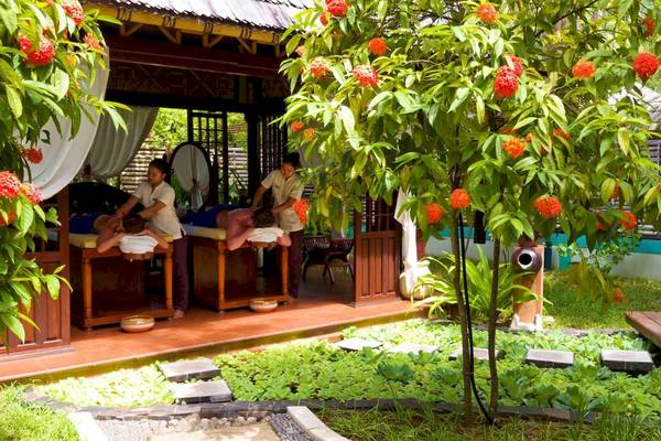 Massage im Freien im Villa Park, Malediven, mit zwei Kunden und Therapeuten unter einem schattigem Pavillon.