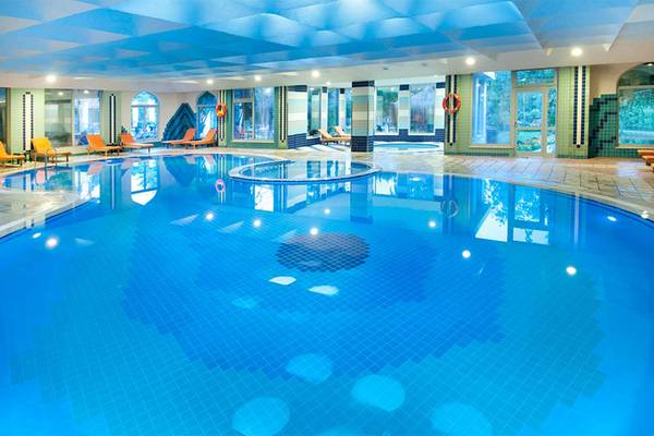 Innenpool des Belconti Resorts mit blauen Fliesen und Lounge-Bereichen.