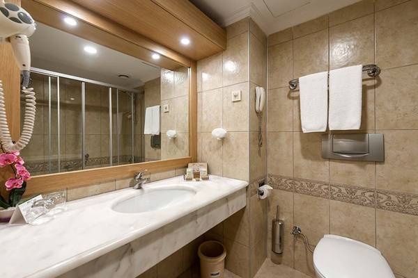 Badezimmer im Belconti Resort mit Waschbecken, Spiegel und Handtüchern.