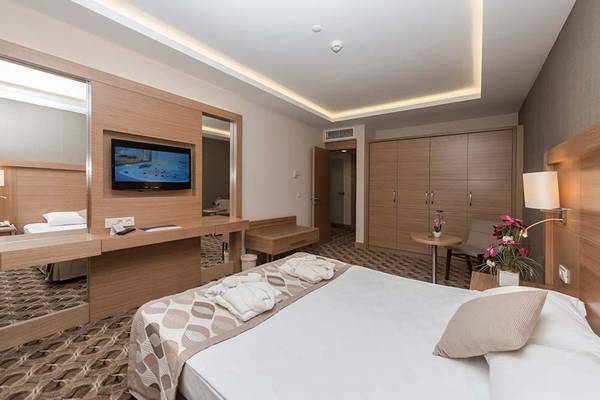 Hotelzimmer im Belconti Resort mit Bett, Fernseher, Spiegel und Dekor.