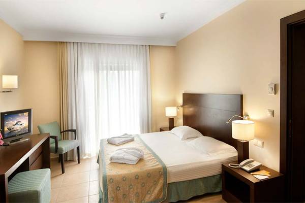 Belconti Resort Hotelzimmer mit Bett, Fernseher und Schreibtisch.