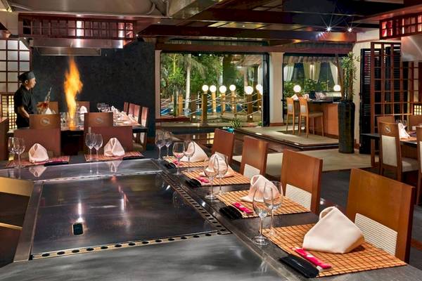 Restaurant des Secrets Bahia Real Resort & Spa mit einem Koch am Grill und gedeckten Tischen