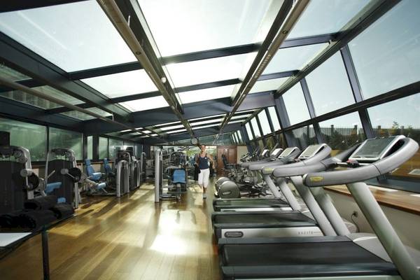 Fitnessstudio im Gewölbe mit Laufbändern und Frau im Hintergrund
