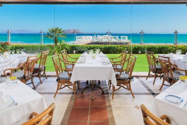 Außenbereich des Restaurants im Secrets Bahia Real Resort & Spa mit Blick auf das Meer.