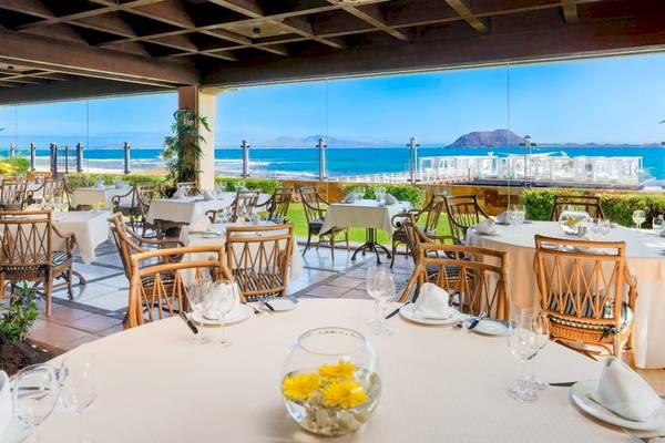 Innenansicht des Restaurants im Secrets Bahia Real Resort & Spa mit Blick auf das Meer.
