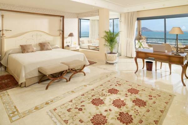 Schlafzimmer der Suite im Secrets Bahia Real Resort & Spa mit Meerblick und modernen Möbeln