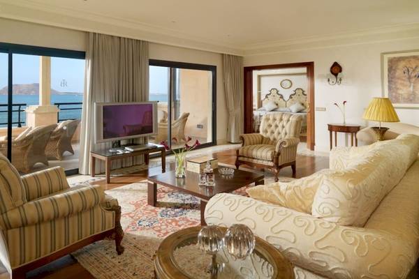 Wohnzimmer im Secrets Bahia Real Resort & Spa mit Meerblick, Fernseher, Sofa, Tisch und Dekor.
