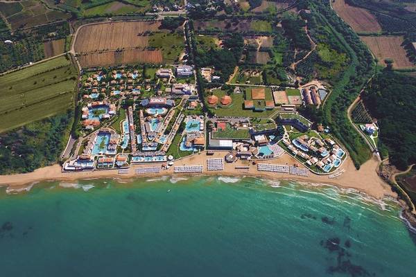 Luftaufnahme des Aldemar Olympian Village Hotels am Strand mit vielen Pools und Gebäuden