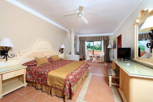 Hotelzimmer mit Bett, Fernseher und Balkon im Bahia Principe Grand Turquesa