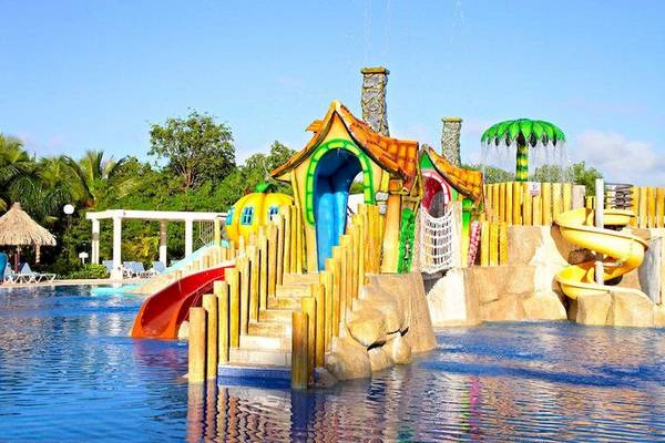 Kinderspielplatz im Bahia Principe Grand Turquesa Hotel mit bunten Rutschen und Wasserspielstationen.