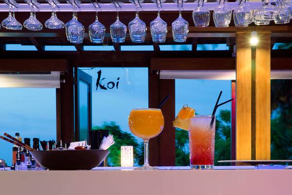 Ein Bartresen im Capo Bay Hotel mit Cocktails und Dekoration.