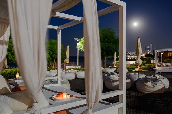 Abendliche Lounge-Bereich des Capo Bay Hotels mit weißen Möbeln und Decken.