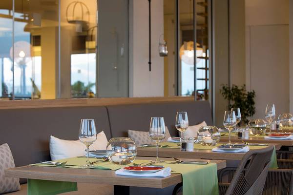 Innenansicht des Capo Bay Hotel Restaurants mit gedeckten Tischen und Gläsern.
