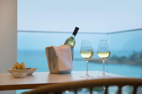Tisch mit zwei Weingläsern und einer Flasche Wein mit Meerblick im Capo Bay Hotel.