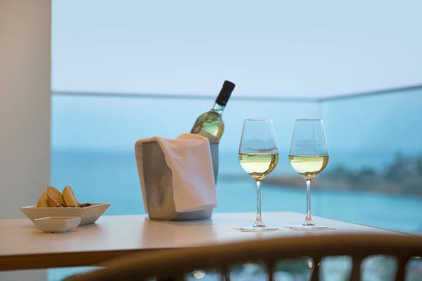 Tisch mit zwei Weingläsern und einer Flasche Wein mit Meerblick im Capo Bay Hotel.