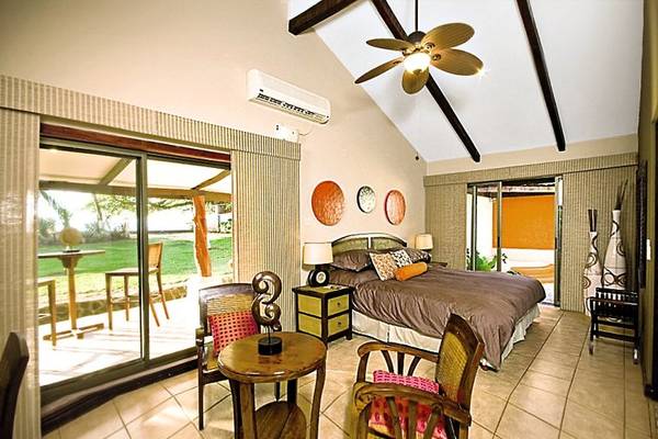 Schlafzimmer mit Terrasse im Hotel Bahia del Sol mit einem großen Bett, Deckenventilator, und Panoramafenstern.
