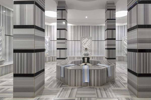 Innenbereich der Sauna im Magic Life Belek Hotel mit grauen Marmorsäulen und einem zentralen Rundsitz.