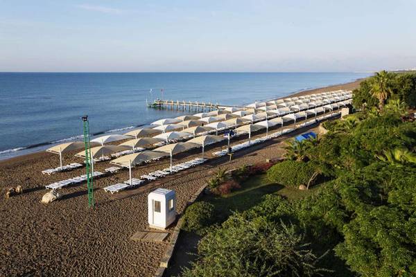 Luftaufnahme des Strandes des Magic Life Belek Hotels mit vielen Liegestühlen und Sonnenschirmen.