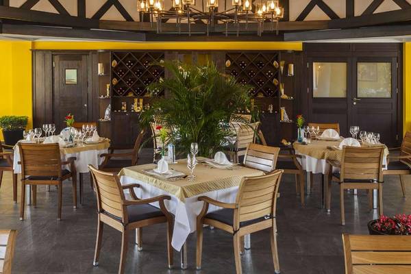 Innenansicht des Restaurants im Magic Life Belek mit gedeckten Tischen und gelben Wänden.