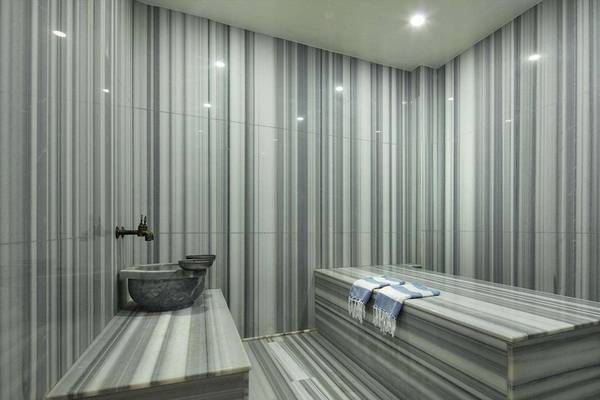 Innenraum des Dampfbads im Magic Life Belek Hotel mit Marmorwänden und einer Badewanne.