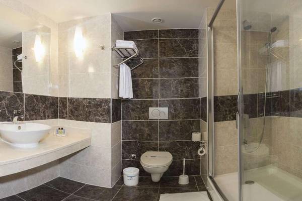 Badezimmer im Magic Life Belek Hotel mit schwarz-weißen Fliesen und einer Dusche.