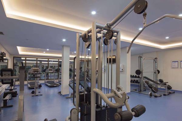 Fitnesscenter im Magic Life Belek Hotel mit verschiedenen Trainingsgeräten und blauen Böden.