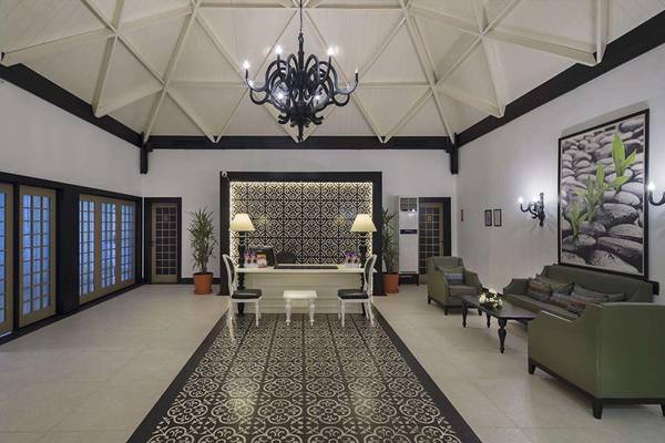 Empfangsbereich des Magic Life Belek Hotels mit schwarzer und weißer Inneneinrichtung.