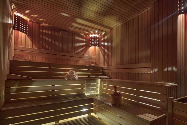 Sauna im Magic Life Belek Hotel mit Holzbänken, Handtüchern und Beleuchtung.