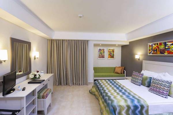 Hotelzimmer im Magic Life Belek mit Doppelbett, Sofa und Fernseher