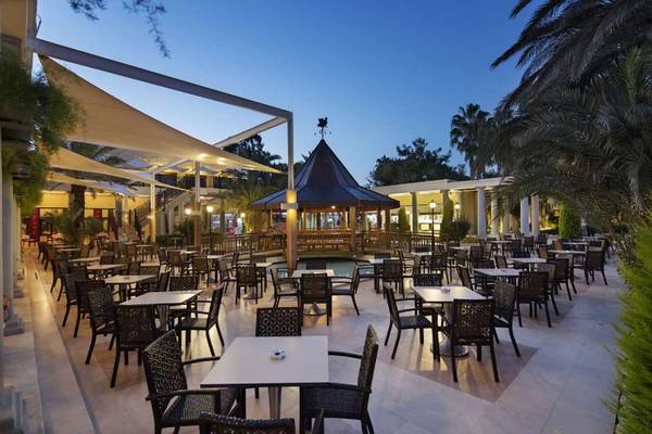 Außenbereich des Magic Life Belek Hotels mit Terrasse, Tischen und Stühlen.