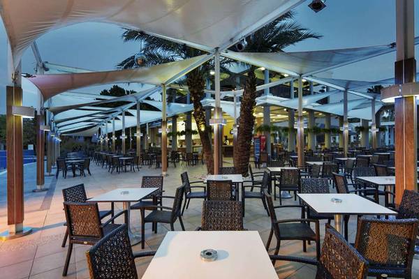 Außenrestaurant im Magic Life Belek Hotel mit gedeckten Tischen und weißen Sonnenschirmen.