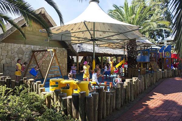 Kinderspielplatz im Magic Life Belek Hotel mit gelben Spielgeräten und einer überdachten Sitzecke.