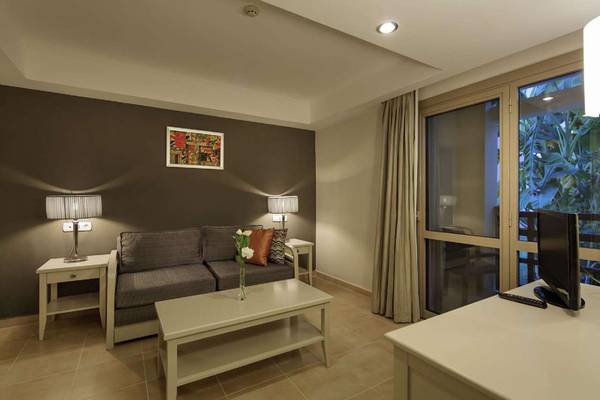 Wohnzimmer des Magic Life Belek Hotels mit Sofa, Tischen und Fernseher