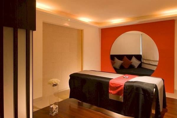 Massagebereich im DoubleTree by Hilton Phuket Banthai Resort mit Rundspiegel und Blumendekor.