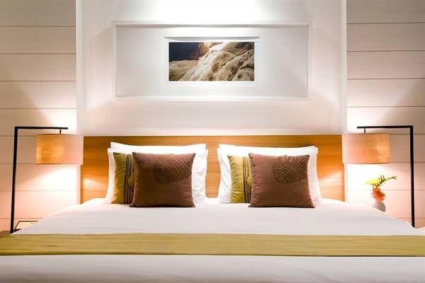 Schlafzimmer im DoubleTree by Hilton Phuket Banthai Resort mit einem Doppelbett, Kissen und Lampen.