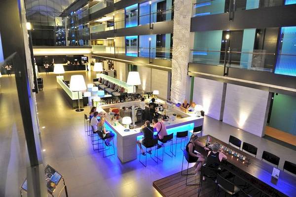 Bar im DoubleTree by Hilton Phuket Banthai Resort mit Gästen an der Theke und Tischen