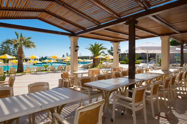 Außenterrasse des Iberostar Creta Marine Hotels mit Tischen und Stühlen unter einem Dach.
